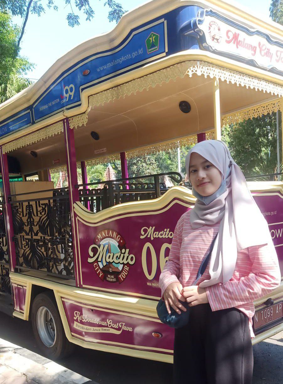 Seorang Wisatawan hendak menaiki Bus Malang City Tour (Macito)